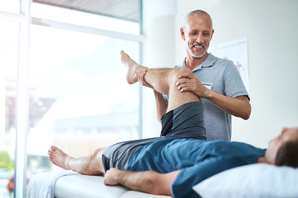 Healthcare,,Physiotherapist,And,Patient,With,Leg,Injury,,Stretching,And,Recovery