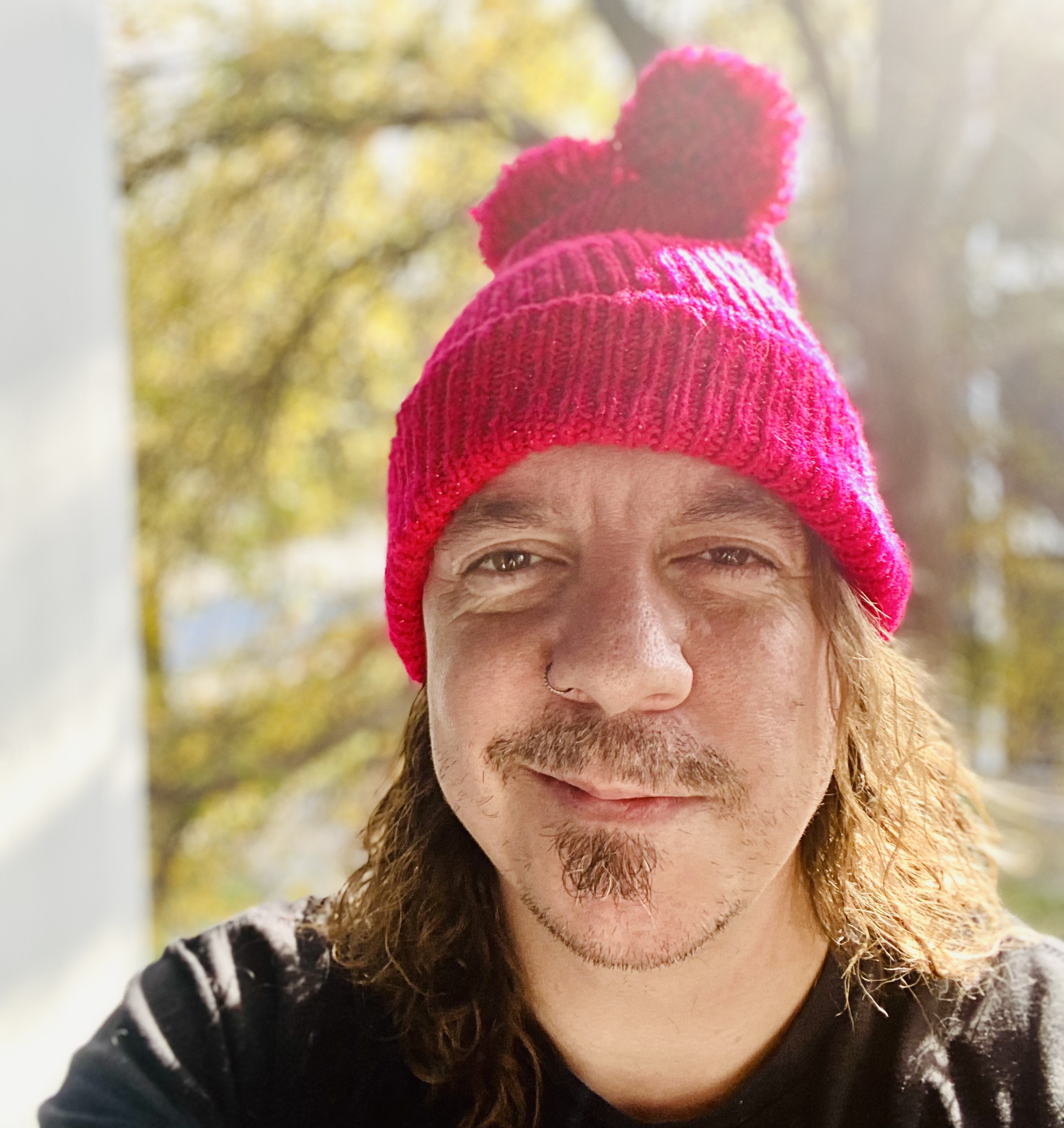 Caeriel is wearing a pink had and smiling