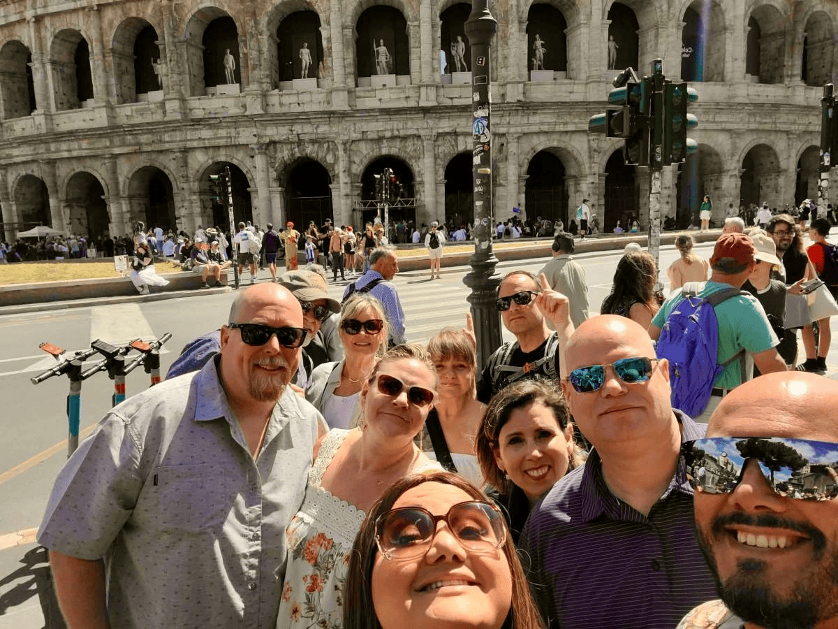Impulsive Escape Travel group sightseeing together at the Colosseum in Rome, Italy