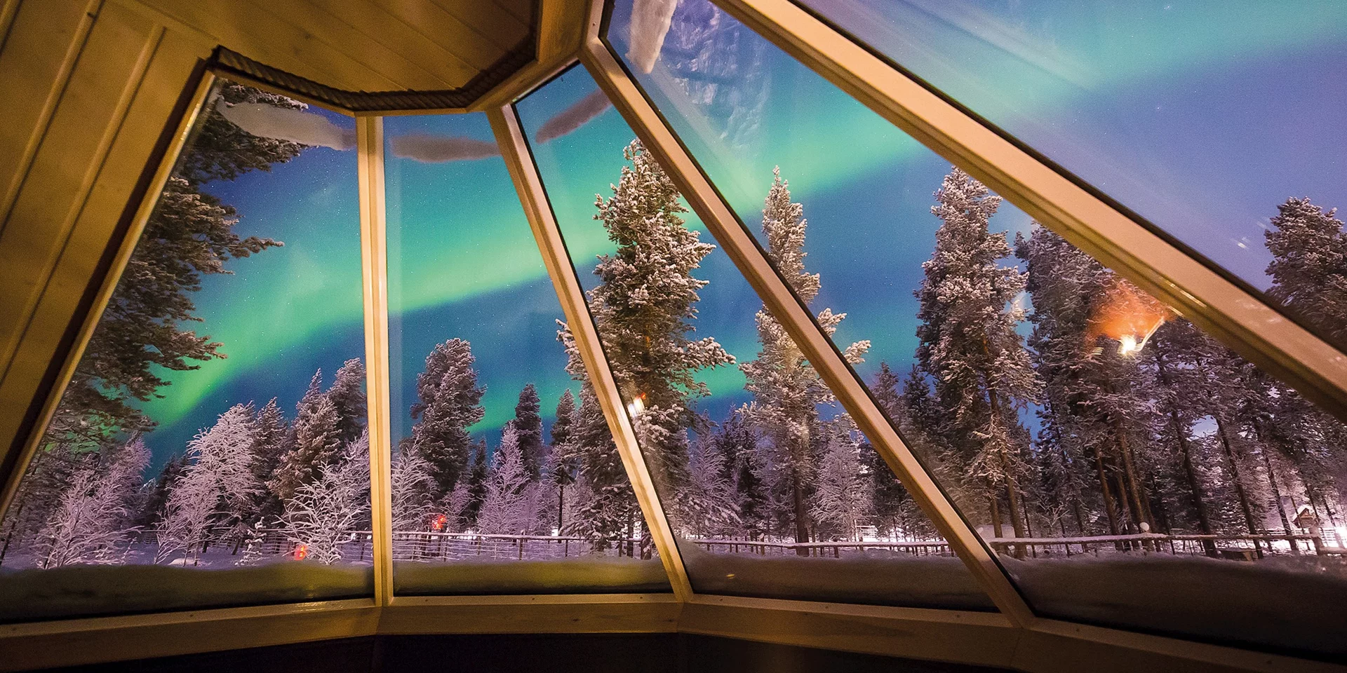 Northern Lights glowing over a snowy Scandinavian winter landscape