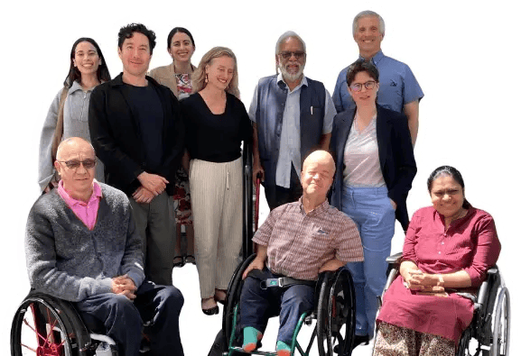CIP team members posing together outdoors, including wheelchair users and colleagues standing behind them