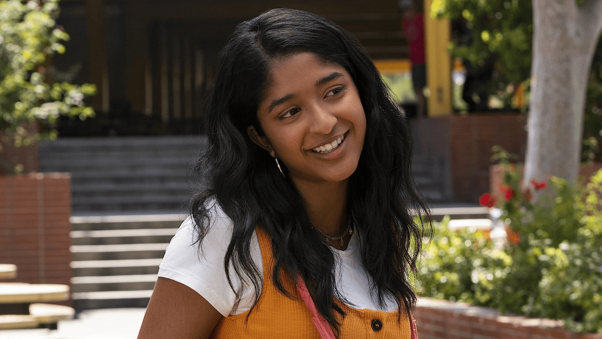 A young girl smiles at someone