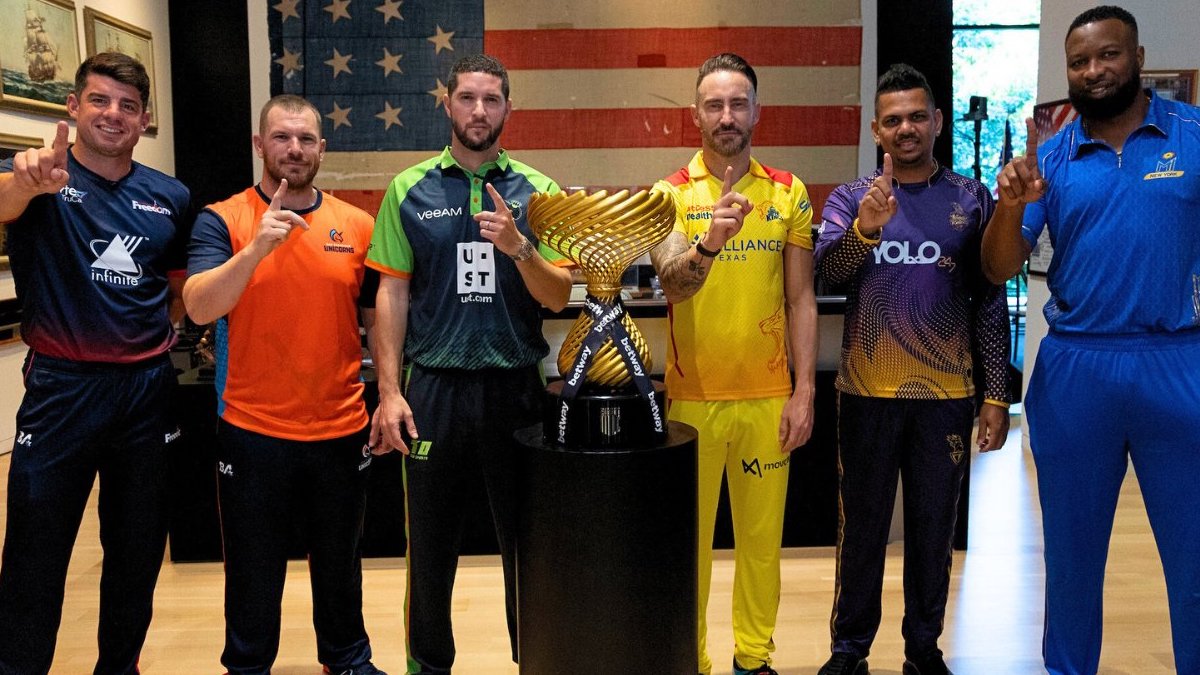 This image shows the captains of the 6 American teams that will participate in the inaugural Major League Cricket tournament. The 6 men are posing in front of the tournament cup. They all have their forefingers raised and pointing to the camera. (Image courtesy: MLC, Twitter)