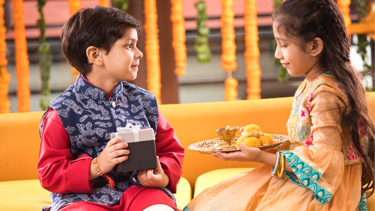 This image shows a boy and a girl, dressed in ethnic Indian wear, celebrating raksha bandhan (Image credit: Canva)