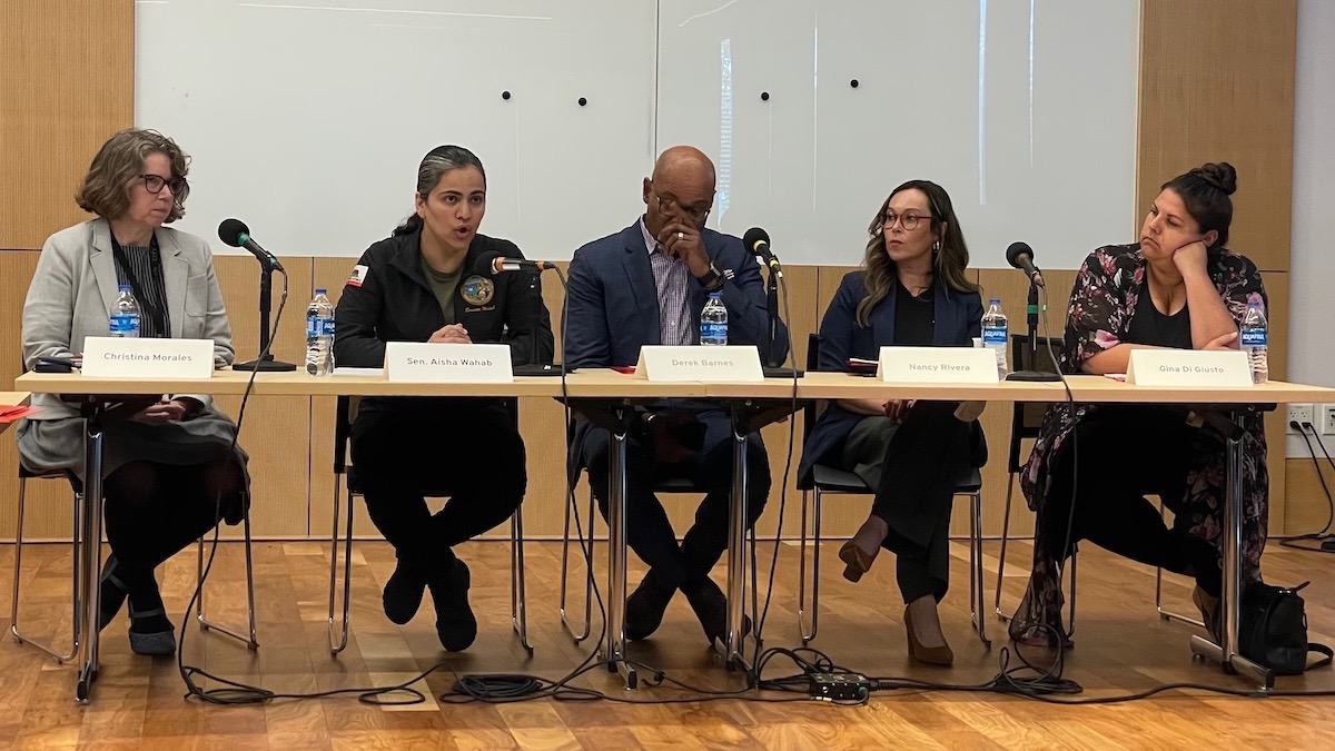 A panel discussion with speakers sitting at a table
