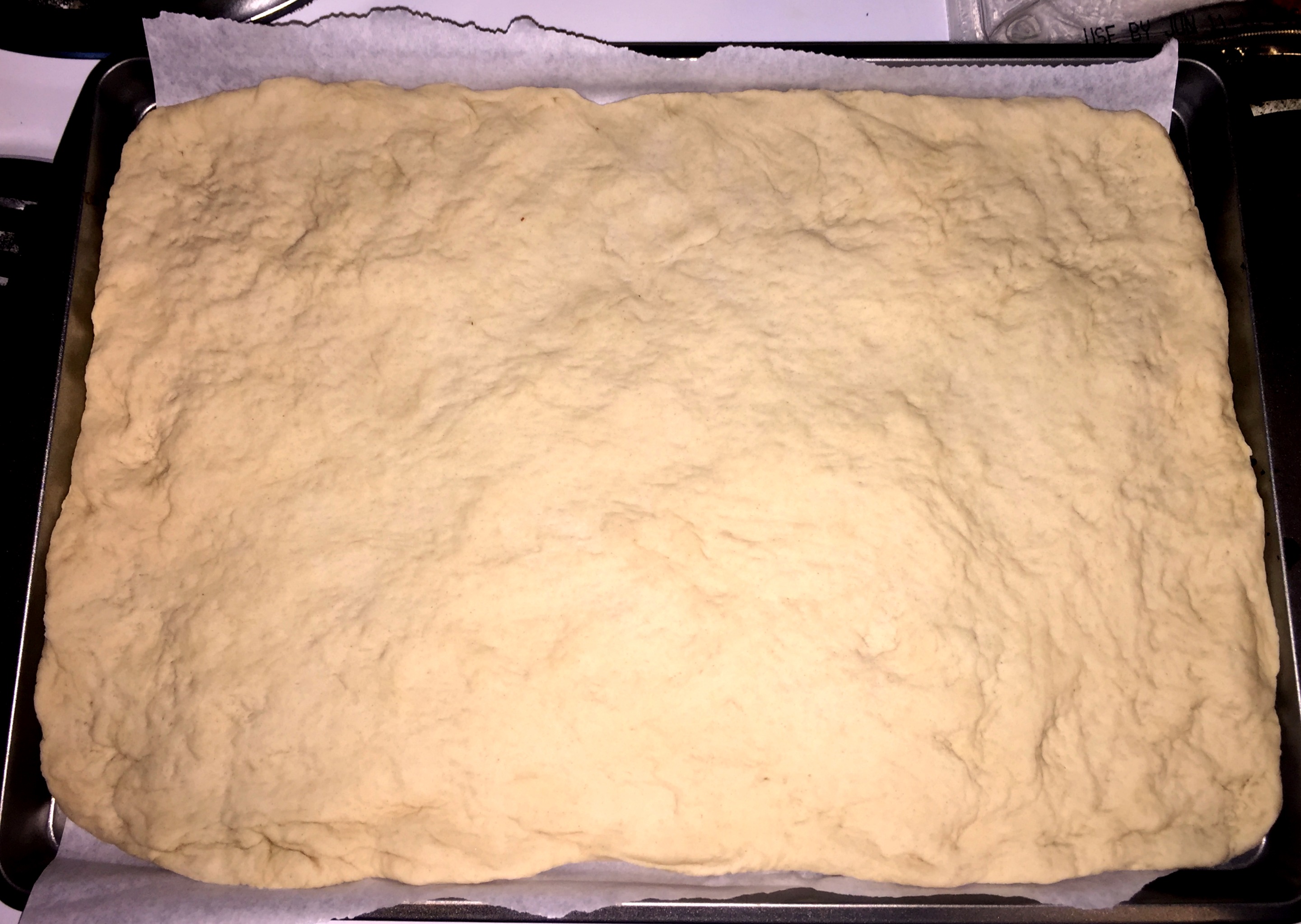 Dough stretched to fill a cookie sheet.