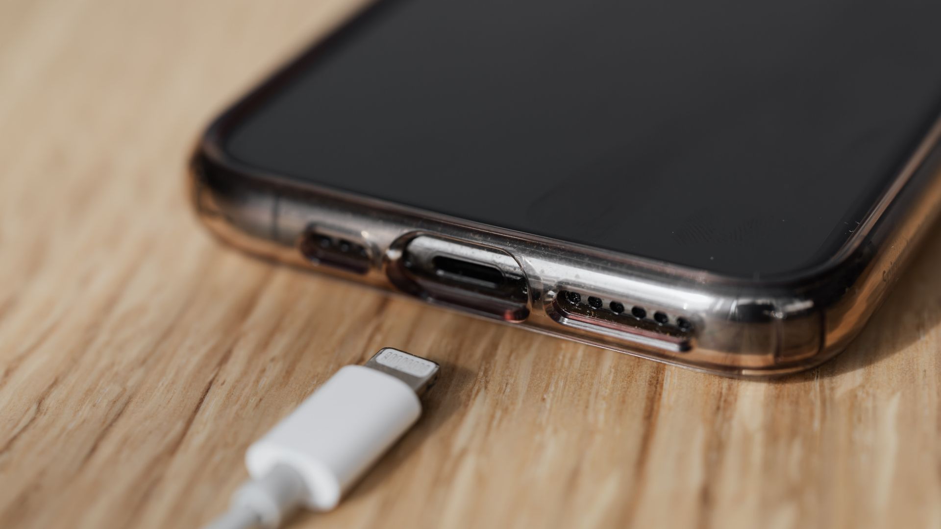 Conector de un teléfono y cable Lightning desconectado sobre una mesa