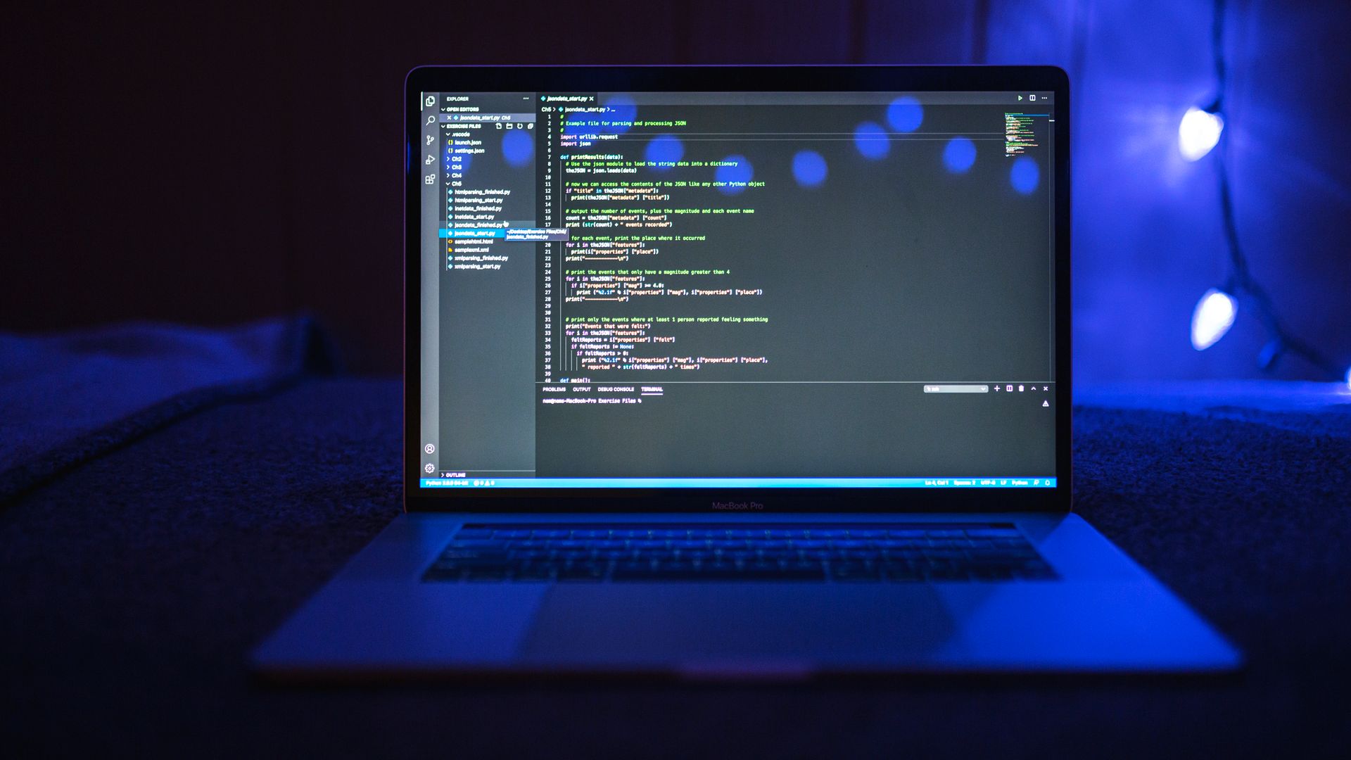 Ordenador portátil con código Python en la pantalla y luz azul