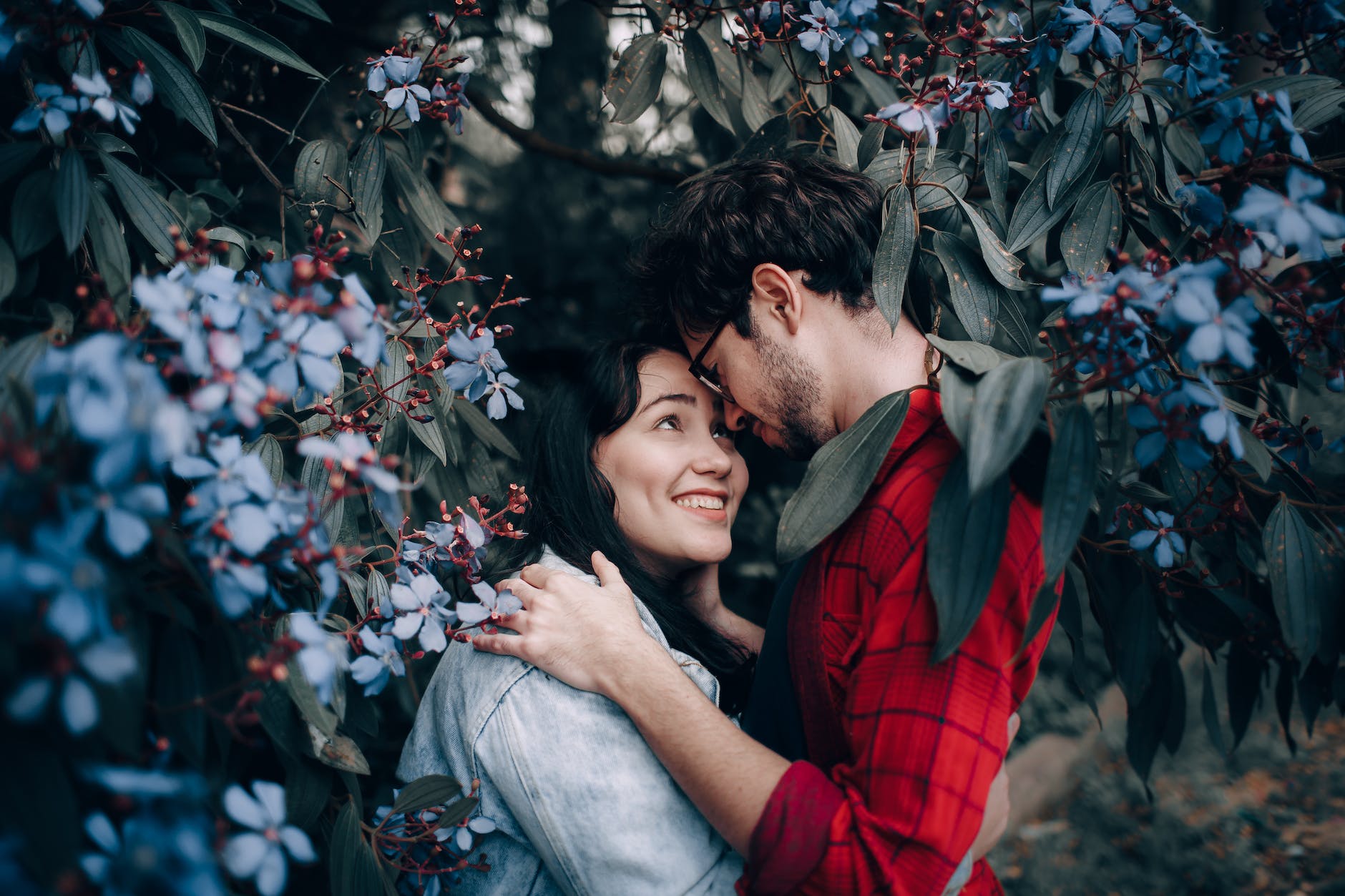 man and woman hugging in the middle of flowers