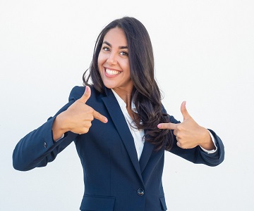 Happy joyful businesswoman pointing index fingers at herself