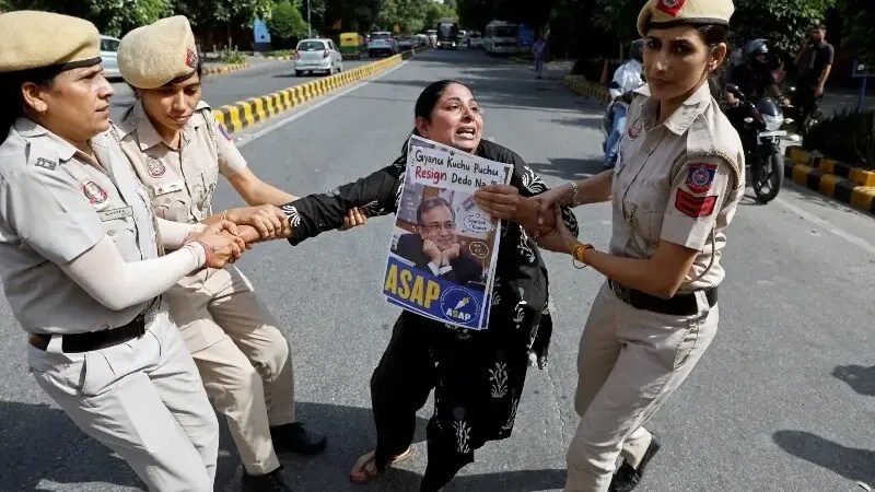 Police detain a protester in New Delhi during a demonstration over voter-roll revisions.