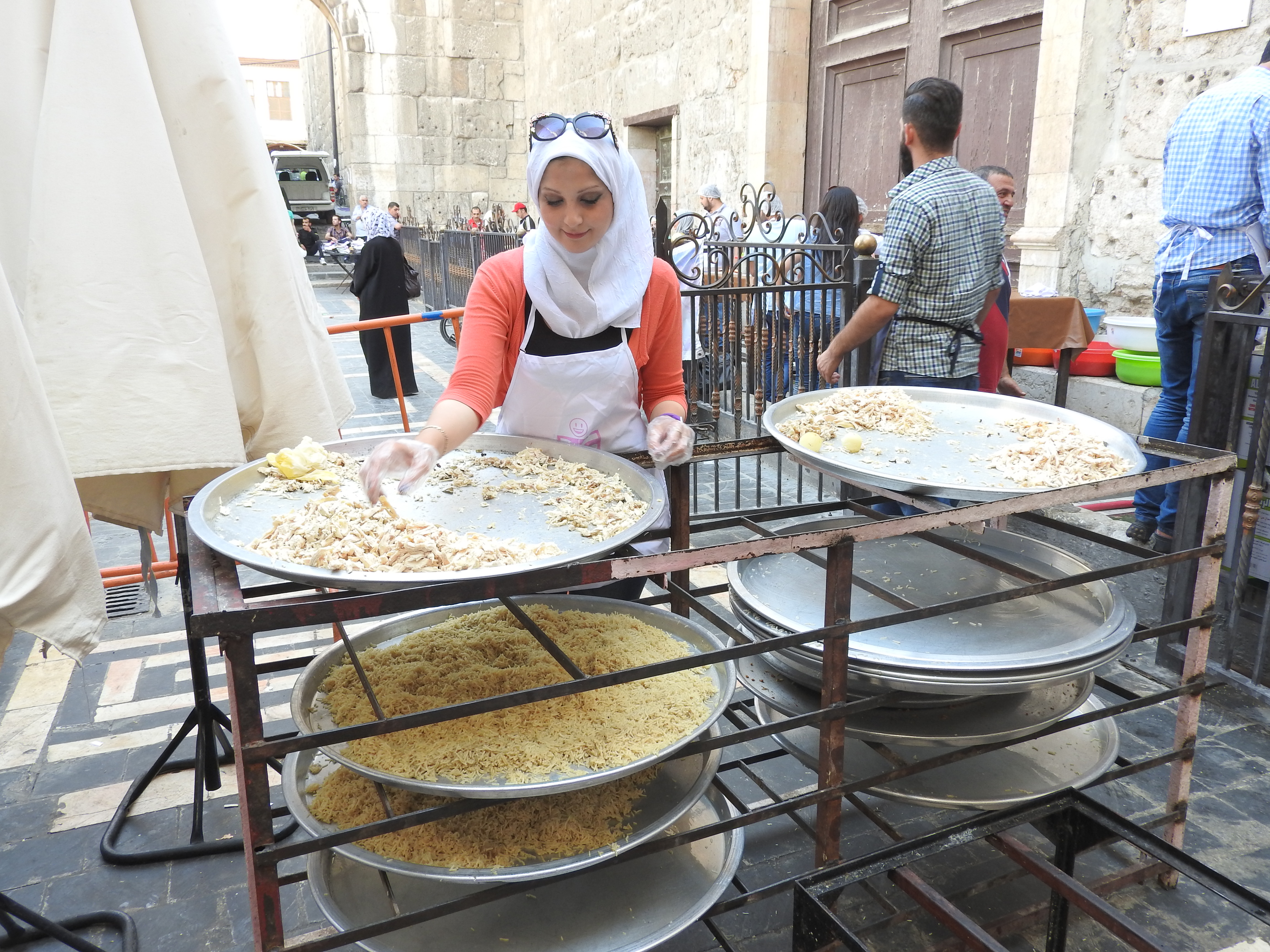 Behind the Umayyad Mosque in Old Damascus, one of tens of volunteers daily helps prepare the Iftar (fast-breaking) meals that the Saaed Association was serving to impoverished Damascus residents, even delivering to those unable to pick up meals themselves. Starting with 3,000 recipients, by the end of Ramadan, the volunteers were providing 10,000 meals daily in Damascus alone, with another combined 7,000 meals prepared in Hama and Homs. https://www.mintpressnews.com/damascus-life-returns-5-years-after-nato-destabilization-efforts/218601/