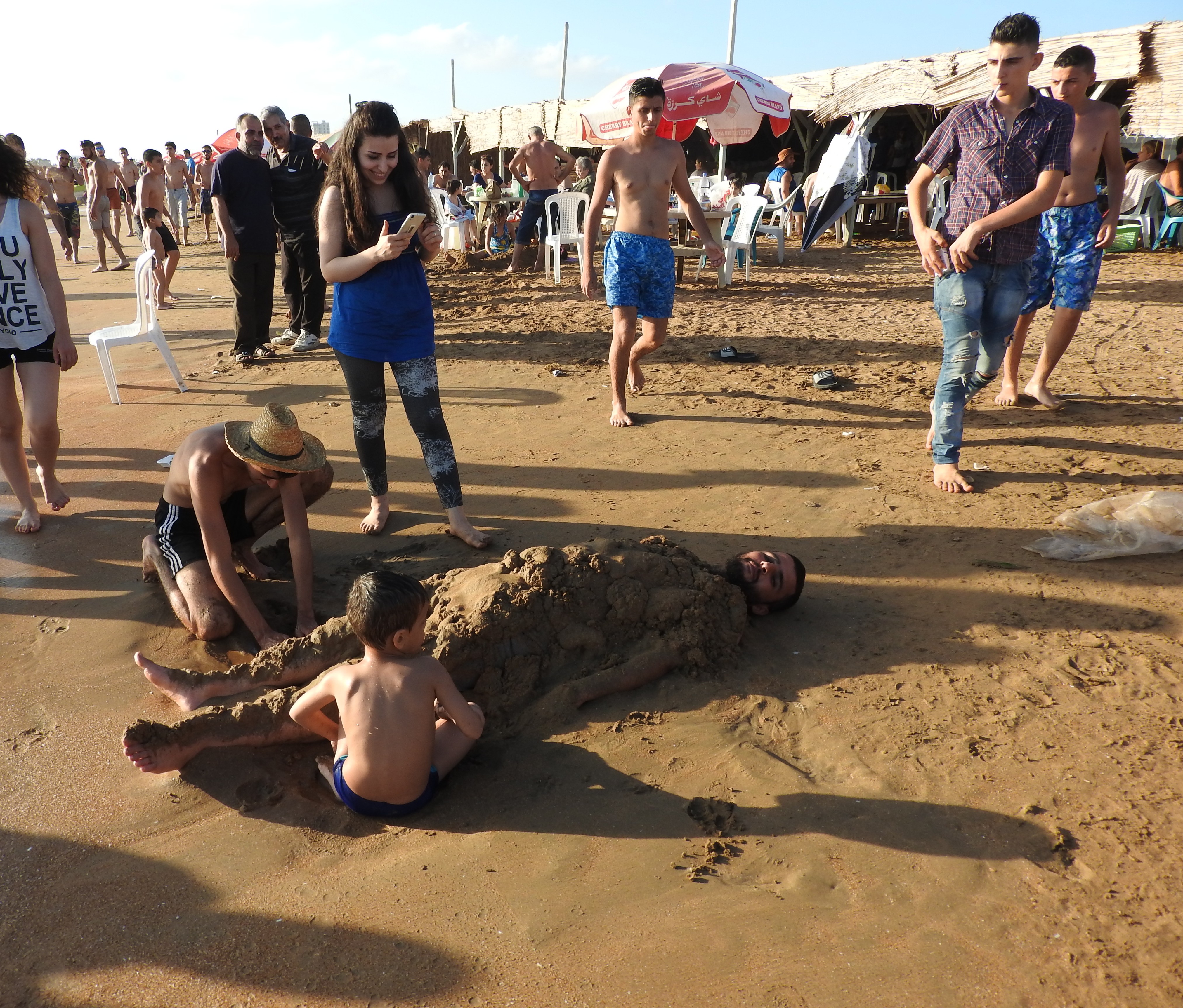 In 2016, I visited Tartous, to see the transportation terminal which was attacked by Western-backed terrorists on May 23rd, the same morning a transport hub (and street and hospital) in Jableh (which I also visited) was attacked. Tartous houses 1 million internally-displaced from all over Syria, including people from Deir ez-Zor, Raqqa, Aleppo, Homs, and elsewhere, according to the Governor of Aleppo (as of mid-2016), who said the city is known as "mini-Syria" in recent years due to its hosting of Syrians from all over. "The 1 million IDPs share Tartous' resources, schools, and hospitals with 1 million inhabitants." They are not housed in tents and camps, but in schools/other buildings-turned refugee centres, as well as houses. I visited one of these centres while in Tartous, also visiting centres in Latakia, Aleppo, Damascus over the past few years. While in Tartous I saw an endless sea of posters of martyred soldiers, billboards listing their names, to give respect to their defense of Syria. I was also treated with an unplanned visit to the sea, where I saw normal beach scenes, and more: Syrians of varying ages and faiths, living, loving, resisting the war of terror on their country. While there, my host made sure to note: "Do not think these people haven't suffered.There isn't a house here that hasn't lost a family member or relative," she said of Syria's fight against terrorism and for the restoration of peace and security. Videos here: https://www.facebook.com/EvaBoBeeva/posts/1611030225573632