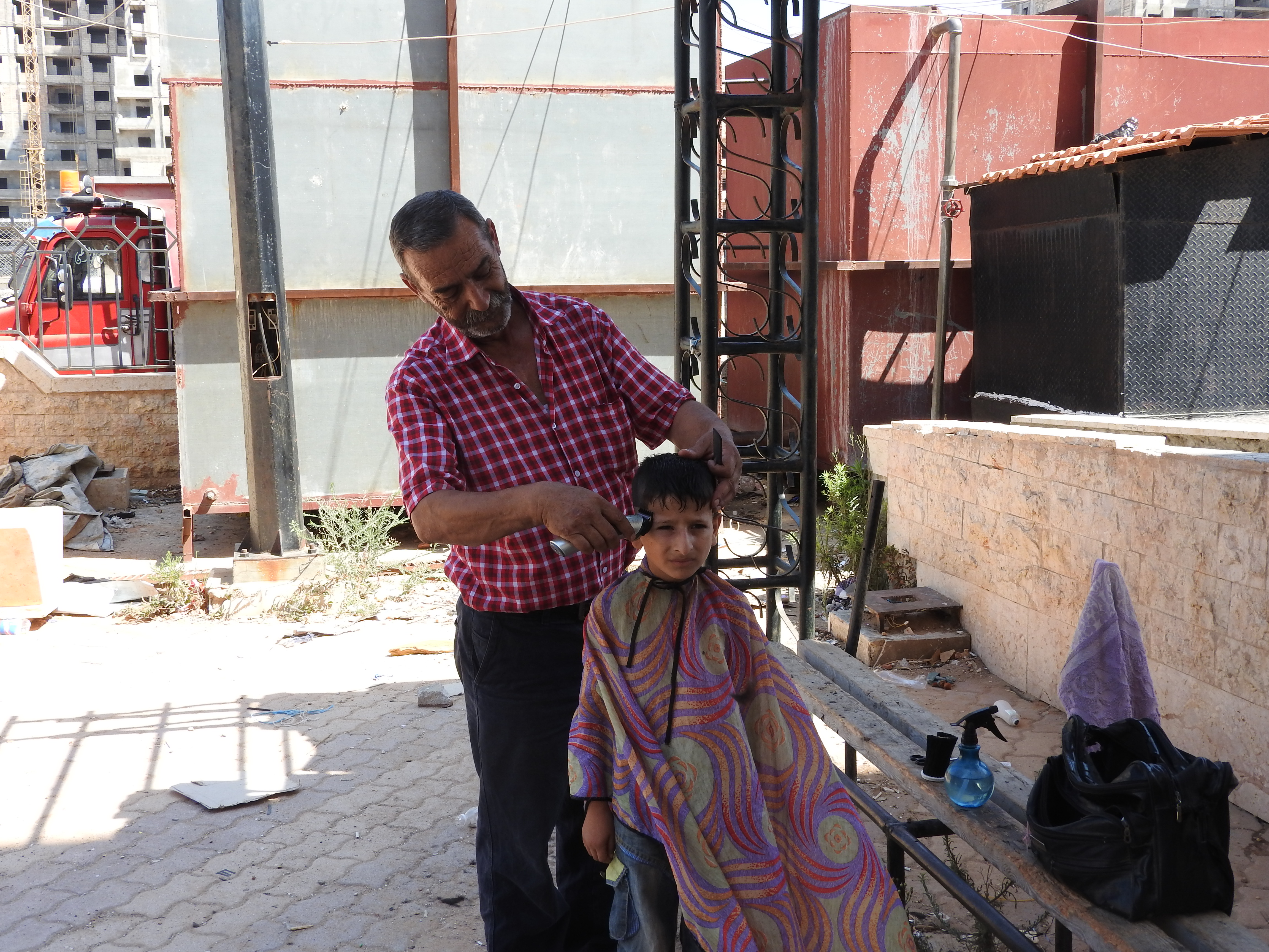 In 2016, I visited Tartous, to see the transportation terminal which was attacked by Western-backed terrorists on May 23rd, the same morning a transport hub (and street and hospital) in Jableh (which I also visited) was attacked. Tartous houses 1 million internally-displaced from all over Syria, including people from Deir ez-Zor, Raqqa, Aleppo, Homs, and elsewhere, according to the Governor of Aleppo (as of mid-2016), who said the city is known as "mini-Syria" in recent years due to its hosting of Syrians from all over. "The 1 million IDPs share Tartous' resources, schools, and hospitals with 1 million inhabitants." They are not housed in tents and camps, but in schools/other buildings-turned refugee centres, as well as houses. I visited one of these centres while in Tartous, also visiting centres in Latakia, Aleppo, Damascus over the past few years. While in Tartous I saw an endless sea of posters of martyred soldiers, billboards listing their names, to give respect to their defense of Syria.