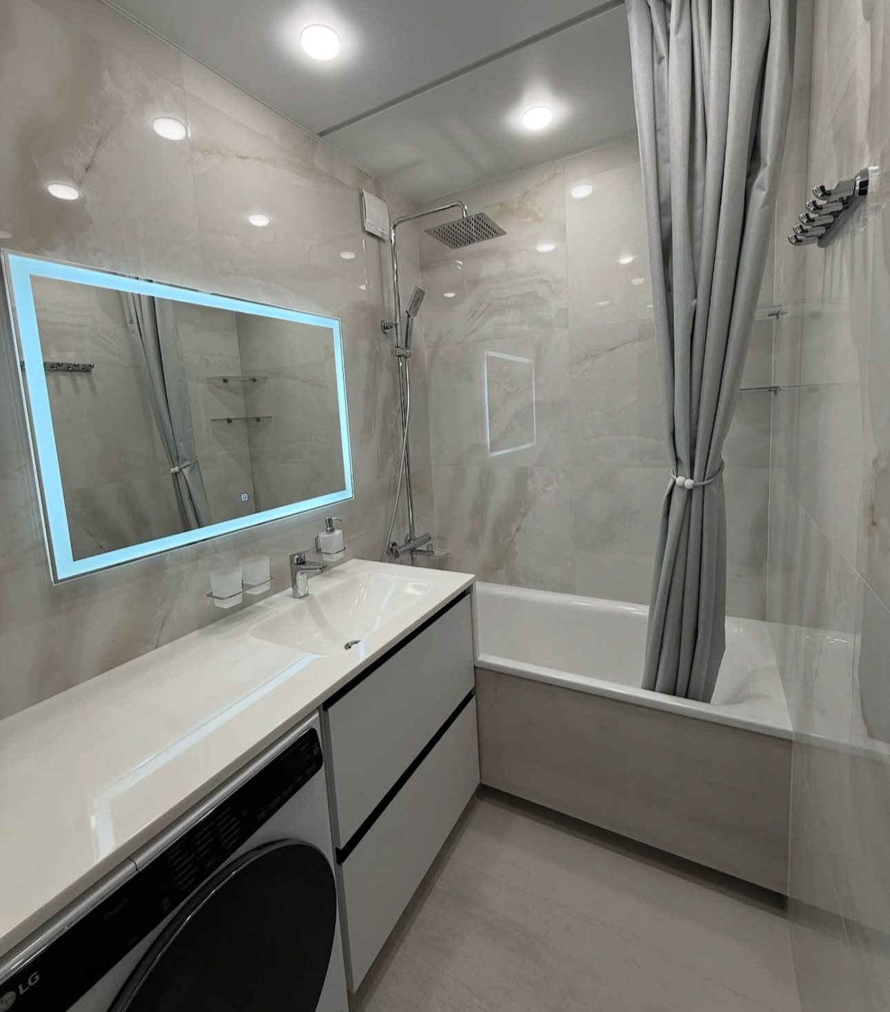 Modern bathroom remodeling project in Manhattan NYC featuring marble tiles, glass shower enclosure, and custom vanity by general contractor.