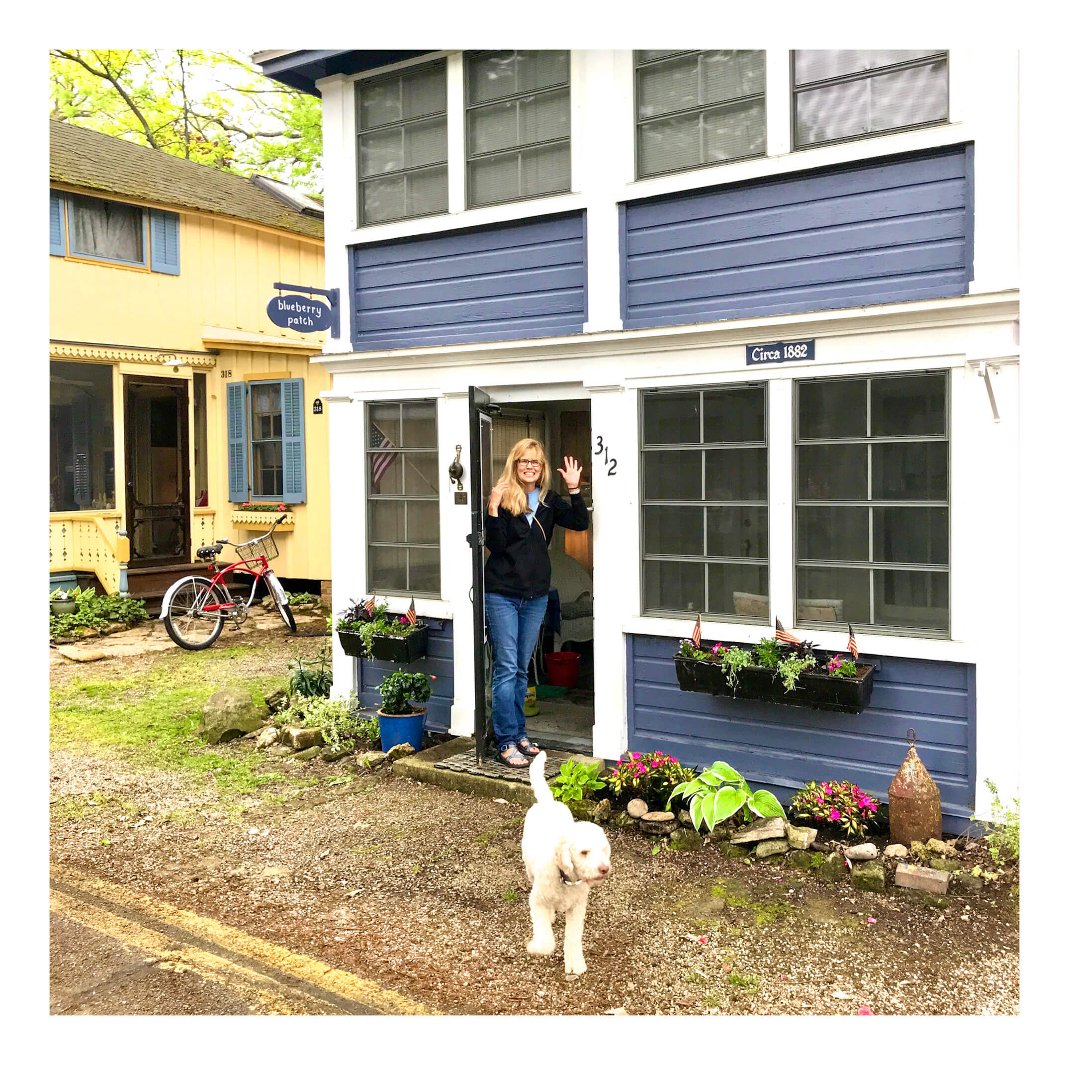 A woman with her Lagotto Romagnolo dog waves from a cottage at Lakeside, Ohio.