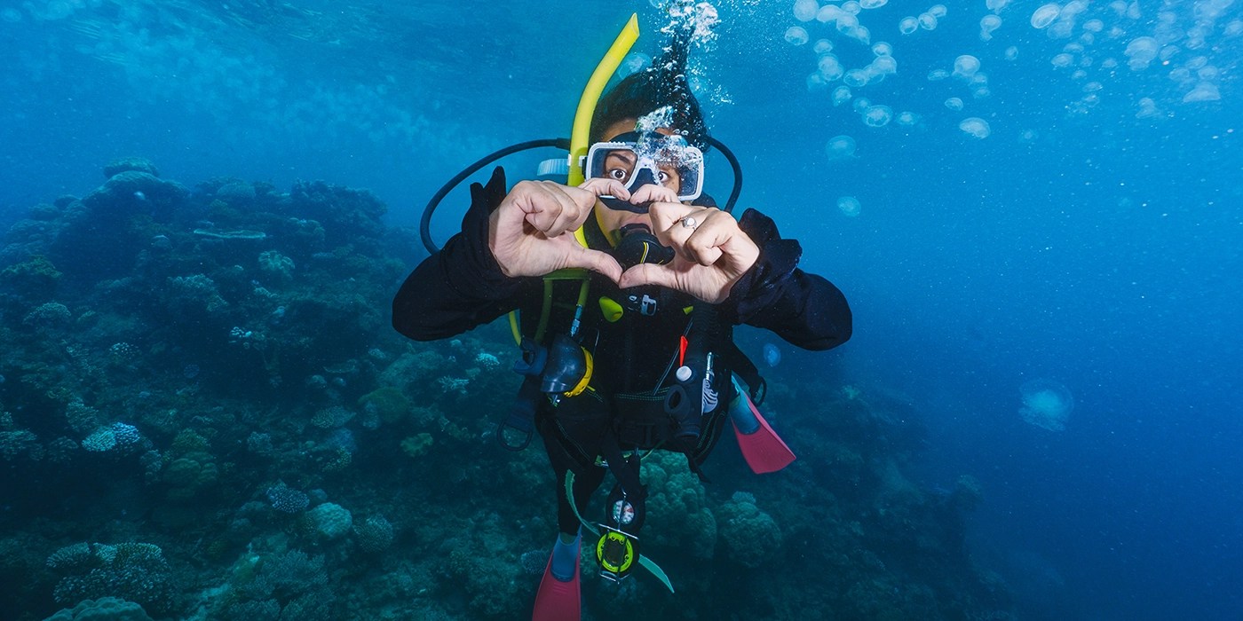 Scuba divers exploring colorful coral reefs in Komodo National Park, Indonesia.