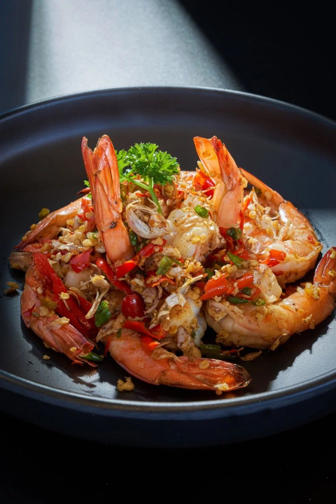 ภาพอาหารจานกุ้งระยะใกล้บนพื้นหลังมืด