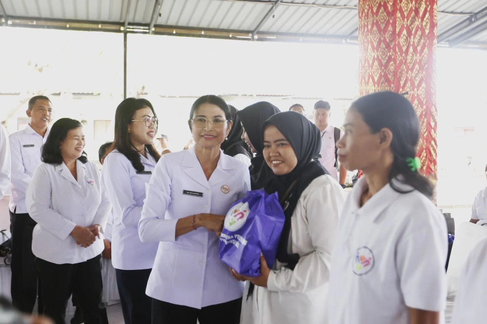 Ny. Eva Satria saat menyerahkan paket sembako dalam aksi sosial TP Posyandu Provinsi Bali di Klungkung.