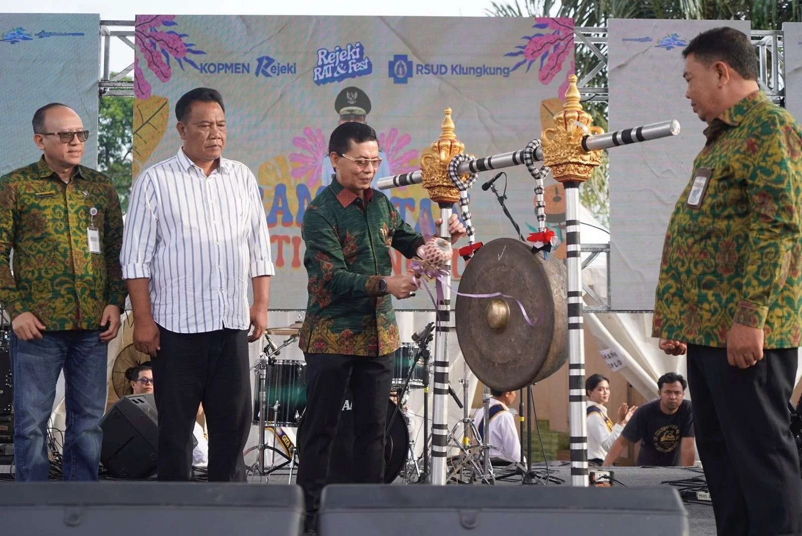 Bupati Klungkung I Made Satria memukul gong saat pembukaan RAT Koperasi Konsumen KOPMEN Rejeki di RSUD Klungkung.