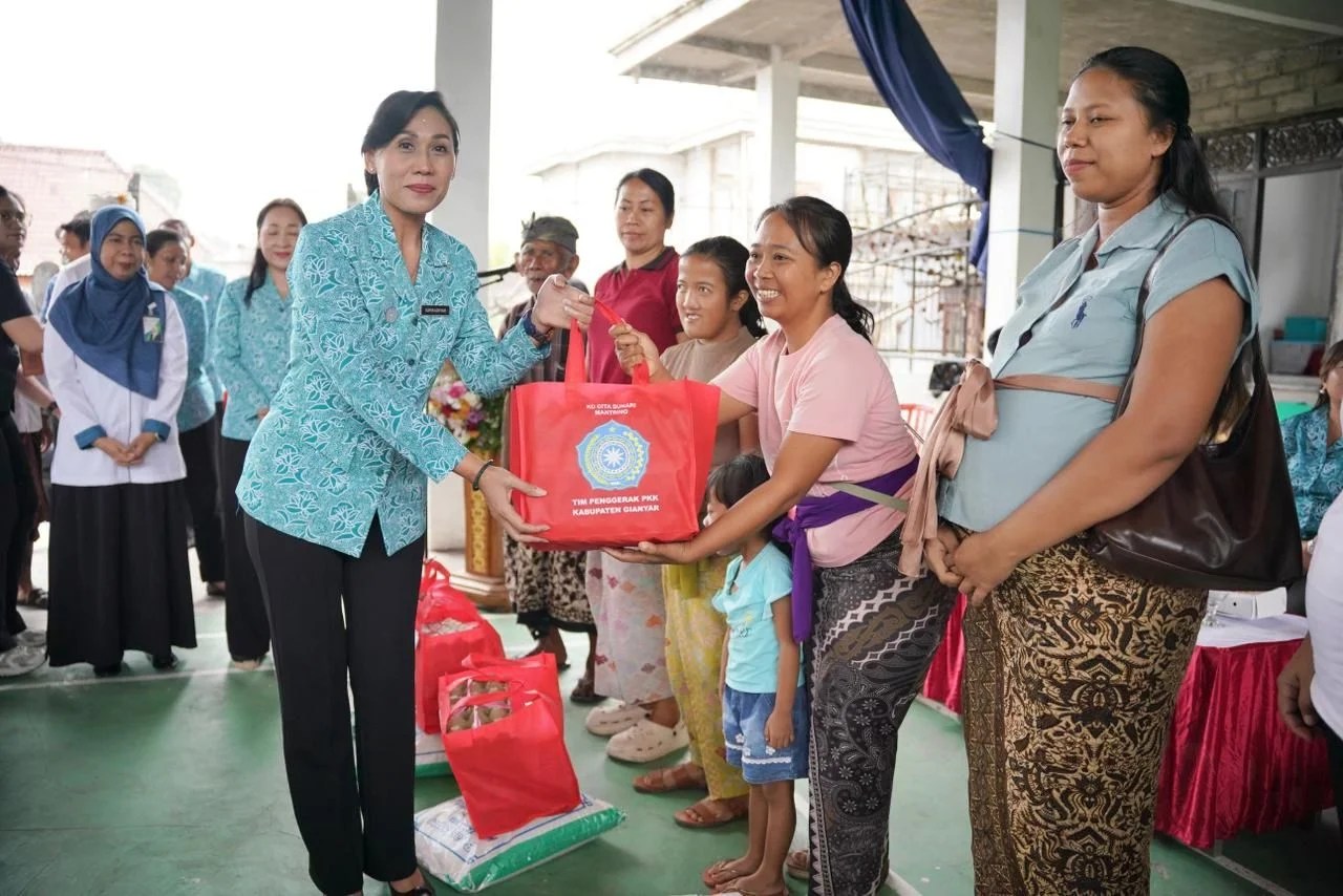 Ketua TP PKK Kabupaten Gianyar saat menyerahkan bantuan paket sembako kepada warga di Desa Petak Kaja.