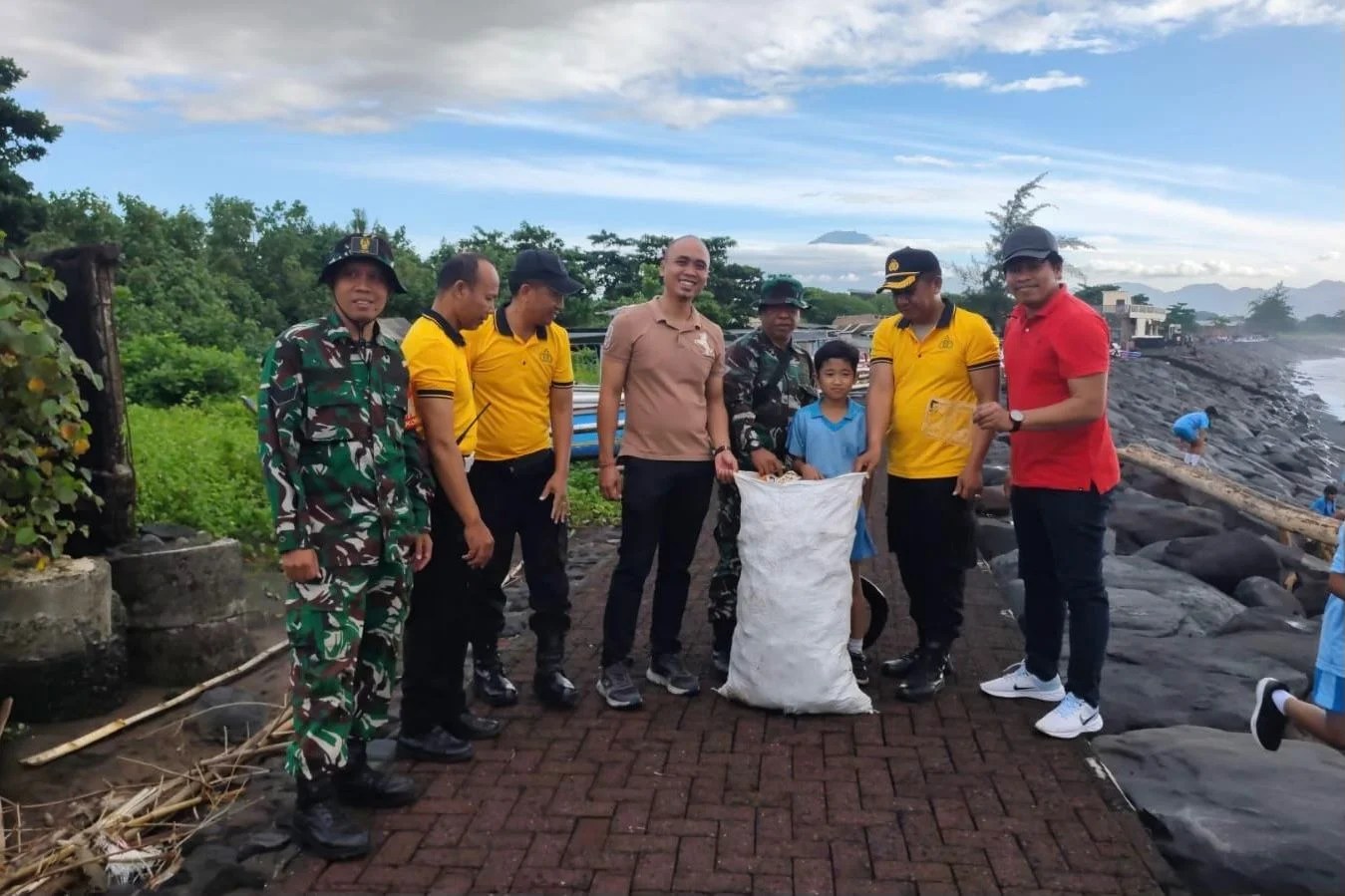 Personel Koramil Gianyar bersama warga melakukan aksi bersih-bersih Pantai Lebih untuk menjaga kelestarian lingkungan.