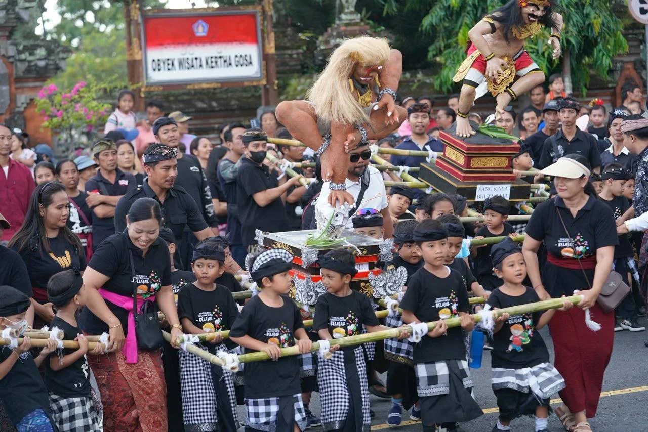 Keceriaan anak-anak PAUD saat mengarak ogoh-ogoh mini di depan Monumen Ida Dewa Agung Jambe, Klungkung.