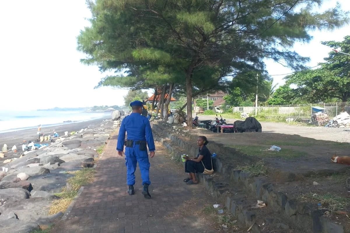 Suasana di pesisir pantai Gianyar saat personel Satpolairud Polres Gianyar memberikan imbauan kebersihan.