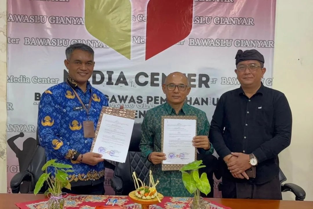 Ketua Bawaslu Gianyar I Wayan Hartawan dan Kepala Dinas PMD I Gede Daging saat menandatangani dokumen PKS.