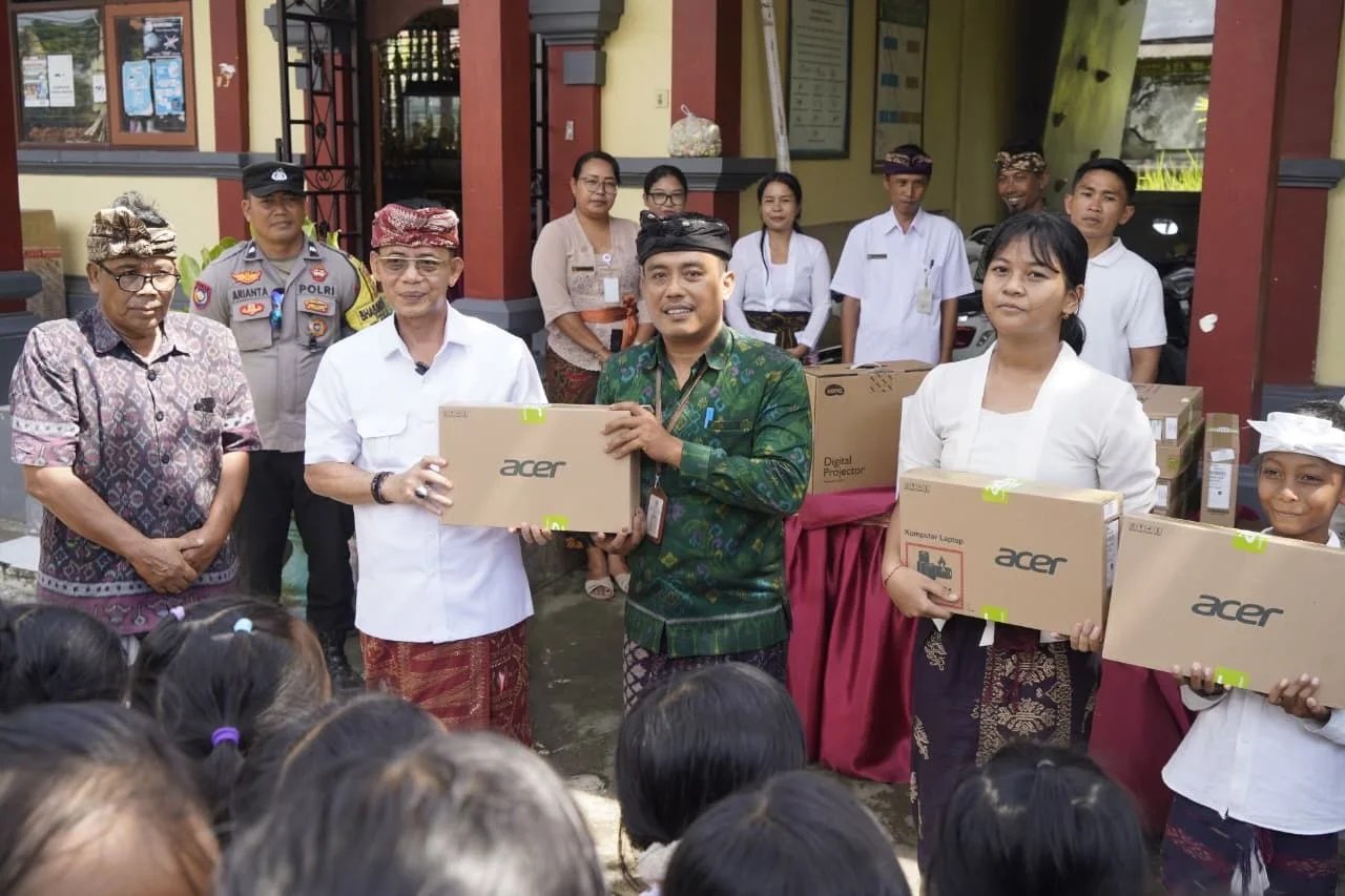 Bupati Klungkung I Made Satria saat menyerahkan bantuan laptop dan sarana belajar secara simbolis kepada kepala sekolah.