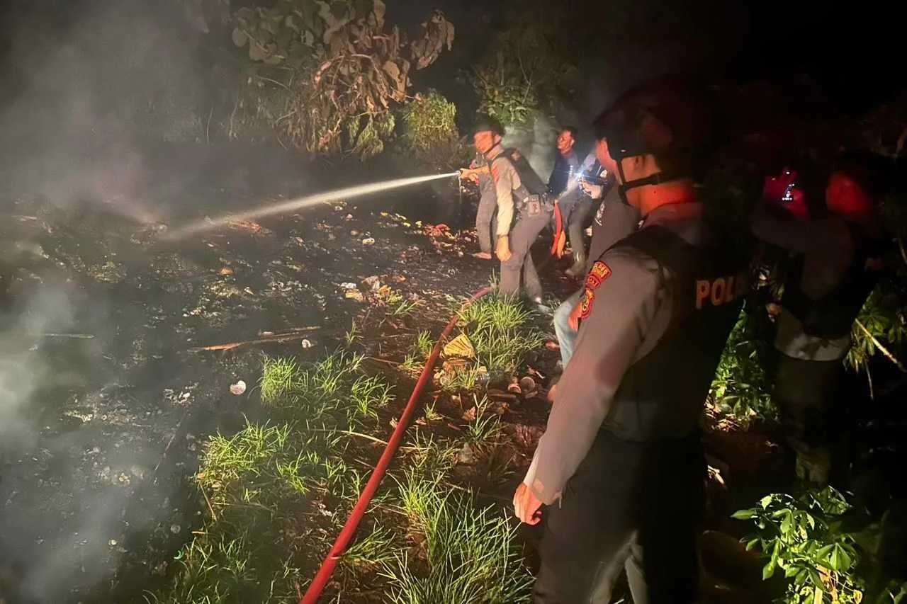 Personel Polsek Nusa Penida dan tim Damkar saat melakukan pemadaman api pada tumpukan sampah di perbukitan Desa Ped.