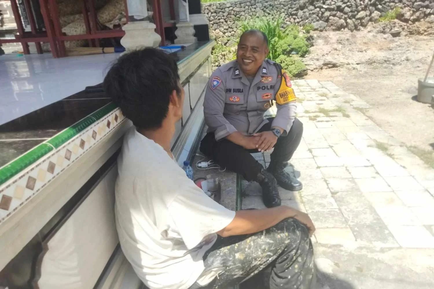 Bhabinkamtibmas Desa Batununggul Aiptu Dewa Susila Dharma saat berbincang dengan warga Dusun Batumulapan dalam kegiatan sambang kamtibmas.