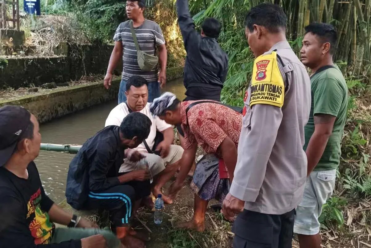 Bhabinkamtibmas Desa Singapadu Tengah Aiptu Ida Bagus Dwija bersama warga saat mengevakuasi I Nyoman K dari bawah tebing Tukad Pengubengan.