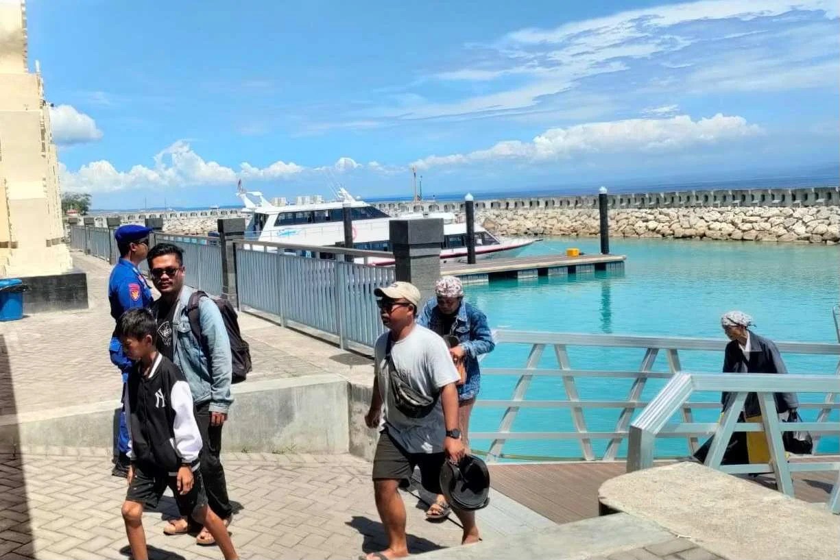 Personel Sat Polairud Polres Klungkung saat memantau aktivitas penumpang di dermaga Pelabuhan Sampalan Nusa Penida guna memastikan prosedur keselamatan terpenuhi.