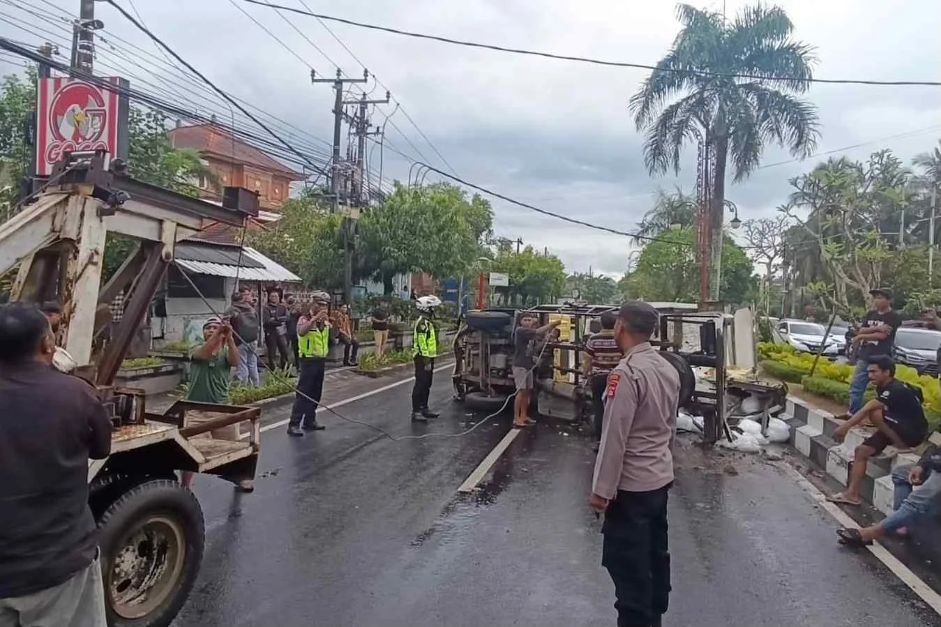 Evakuasi truk pengangkut es kristal yang terguling di Jalan Raya Bypass Dharma Giri Gianyar oleh petugas kepolisian.