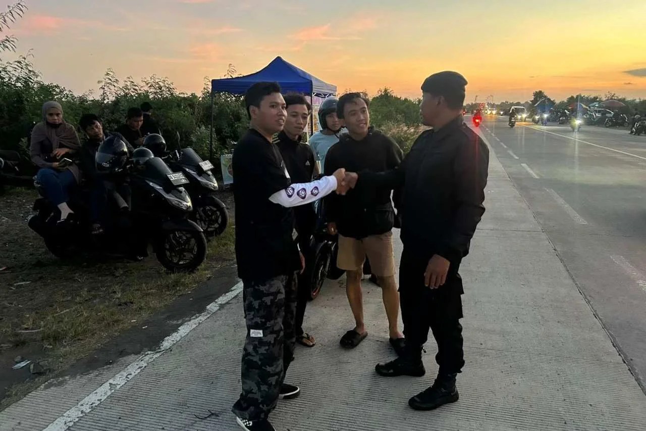 Personel Raimas Sat Samapta Polres Klungkung saat memberikan imbauan kepada para pemuda di Jembatan Merah PKB.