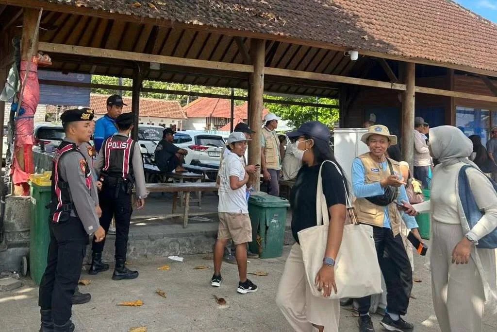Personel Unit Samapta Polsek Nusa Penida Aipda I Wayan Japa saat memantau aktivitas penumpang dan memberikan imbauan kamtibmas di Pelabuhan Buyuk.