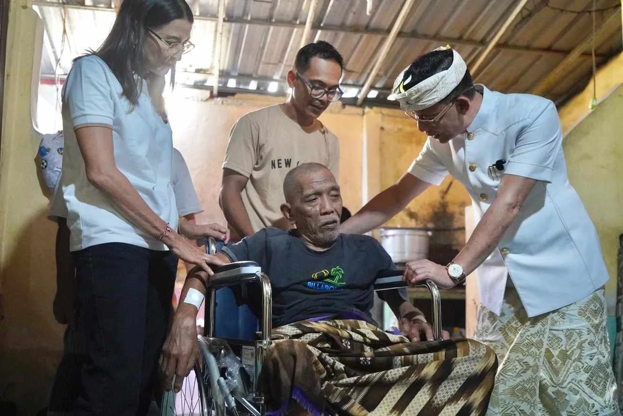 Bupati Klungkung I Made Satria didampingi Kadis Sosial P3A saat menyerahkan langsung bantuan kursi roda kepada Bapak Hairudin di Kampung Lebah Semarapura Kangin.