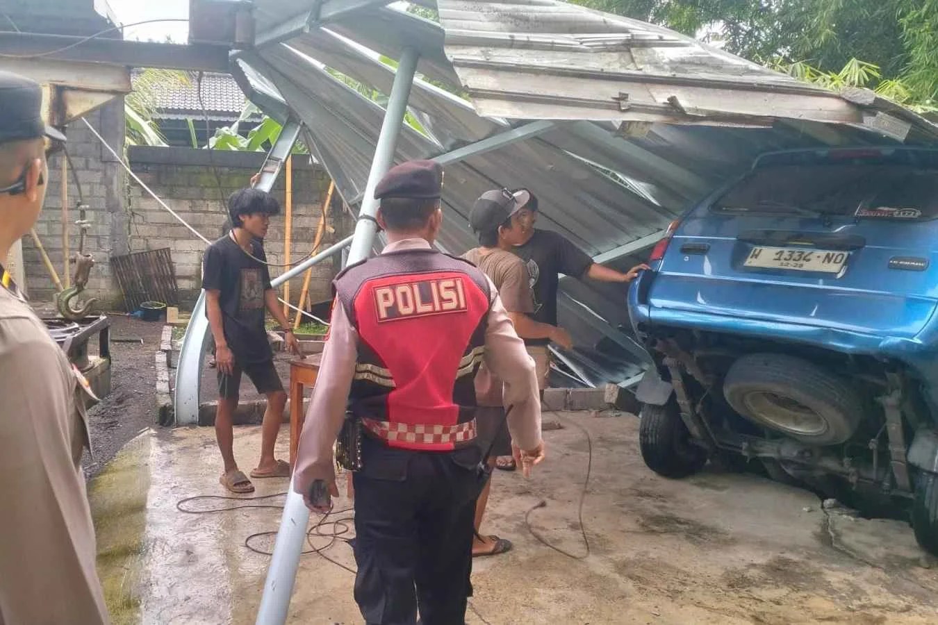 Foto kondisi material tembok penyengker roboh sepanjang 15 meter yang menimpa bangunan garase dan mobil Panther di Banjar Jungut Batuan.