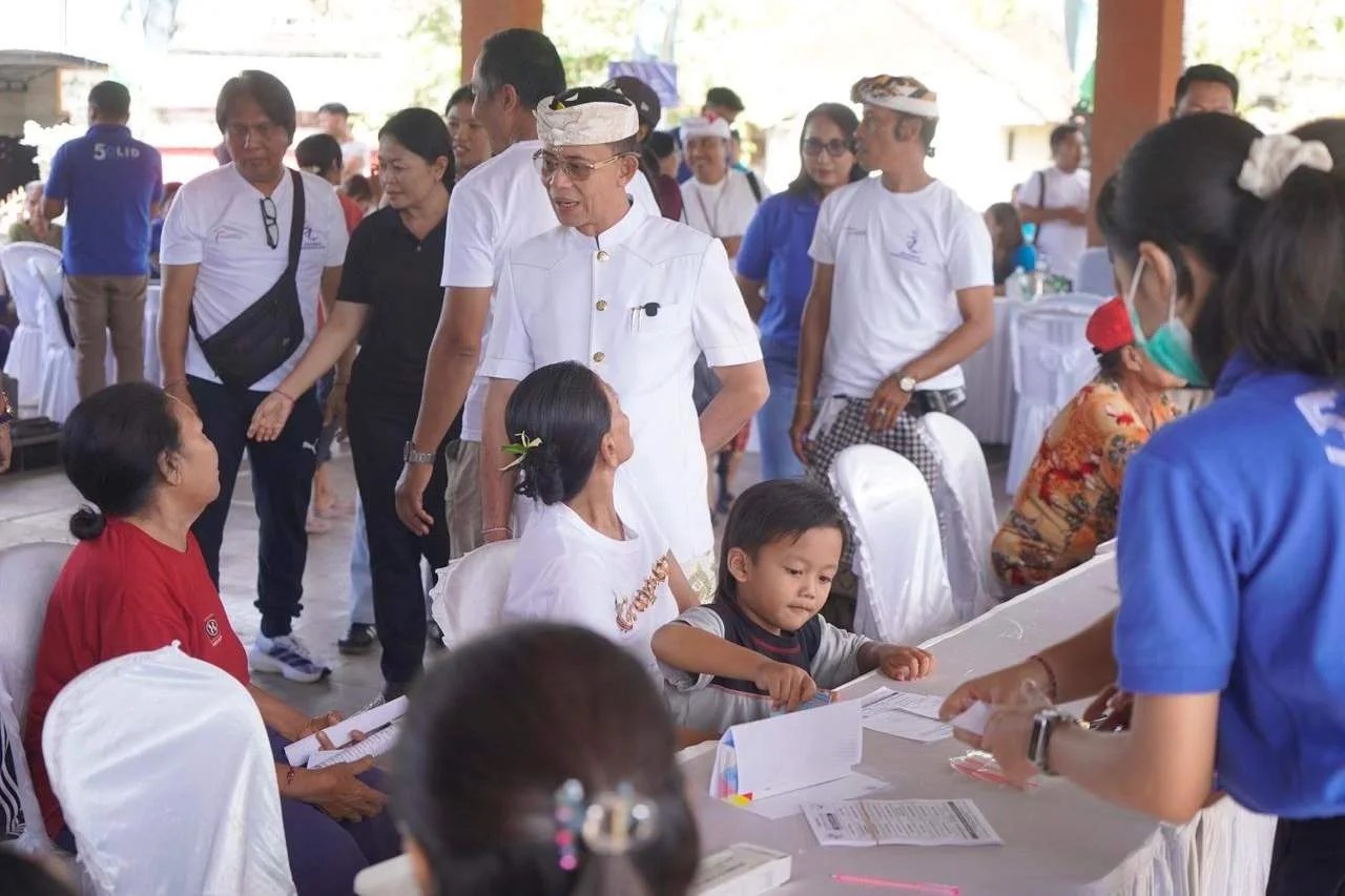 Bupati Klungkung I Made Satria didampingi Ny. Eva Satria saat meninjau pelaksanaan cek kesehatan gratis dan pembagian kacamata di Balai Desa Aan.