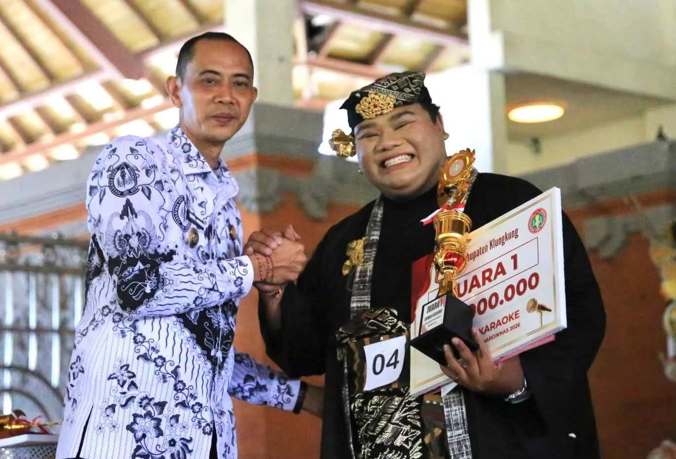 Wakil Bupati Klungkung Tjokorda Gde Surya Putra didampingi Kadisdikpora I Ketut Sujana saat menyerahkan piala kepada pemenang lomba karaoke antarguru di Balai Budaya.