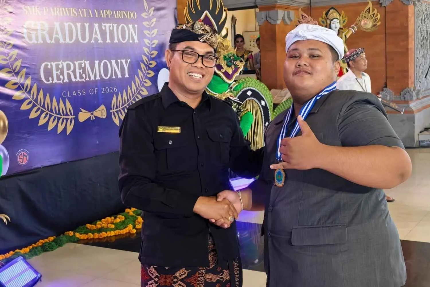 Kepala SMK Pariwisata Yapparindo I Wayan Dharmayasa bersama Ketua Yayasan I Ketut Mandia saat melepas 447 siswa dalam prosesi graduation gratis di Balai Budaya Klungkung.