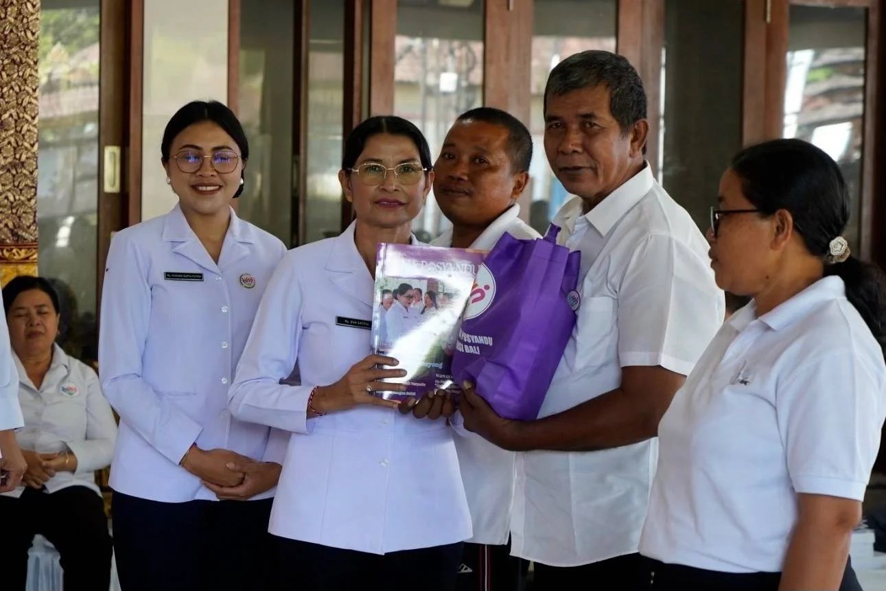 Ketua TP Posyandu Klungkung Ny. Eva Satria saat menyerahkan bantuan paket beras dan telur secara simbolis kepada perwakilan kader Posyandu di Dawan.