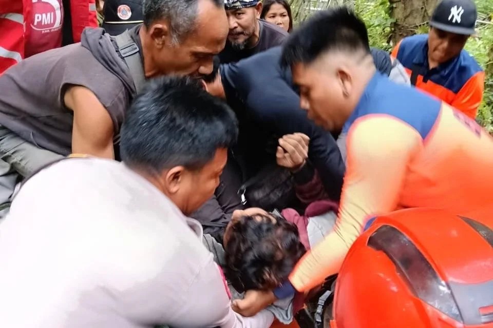 Tim Reaksi Cepat (TRC) BPBD Gianyar bersama petugas PMI saat mengevakuasi korban terjatuh dari pohon menggunakan tandu di Ubud.