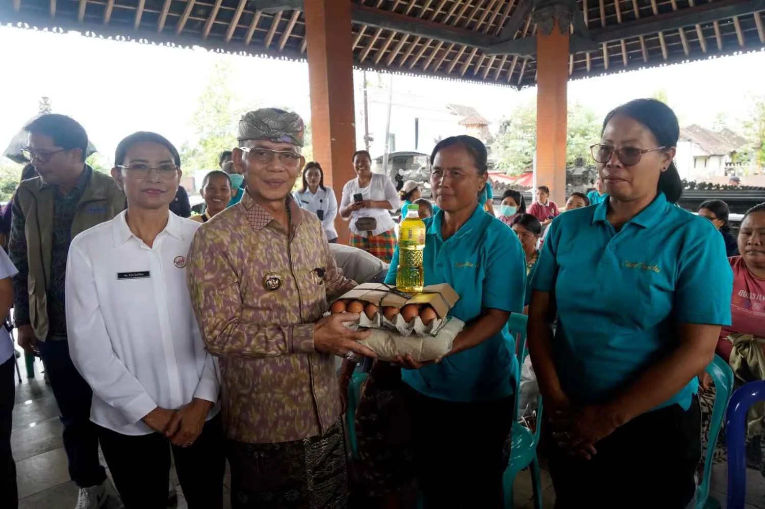 Bupati Klungkung I Made Satria bersama Ketua TP Posyandu Ny. Eva Satria saat menyerahkan bantuan susu formula dan sembako di Balai Desa Aan.