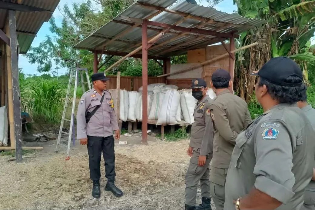 Bhabinkamtibmas Desa Tojan Aiptu I Ketut Narta bersama Perbekel dan Satpol PP Klungkung saat berdialog di lokasi penjemuran bulu ayam Tempek Ume Lepang.