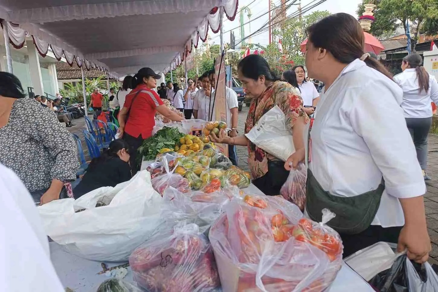 Suasana warga saat berbelanja kebutuhan pokok dengan harga murah di Pasar Tani HUT Bangli ke-822.