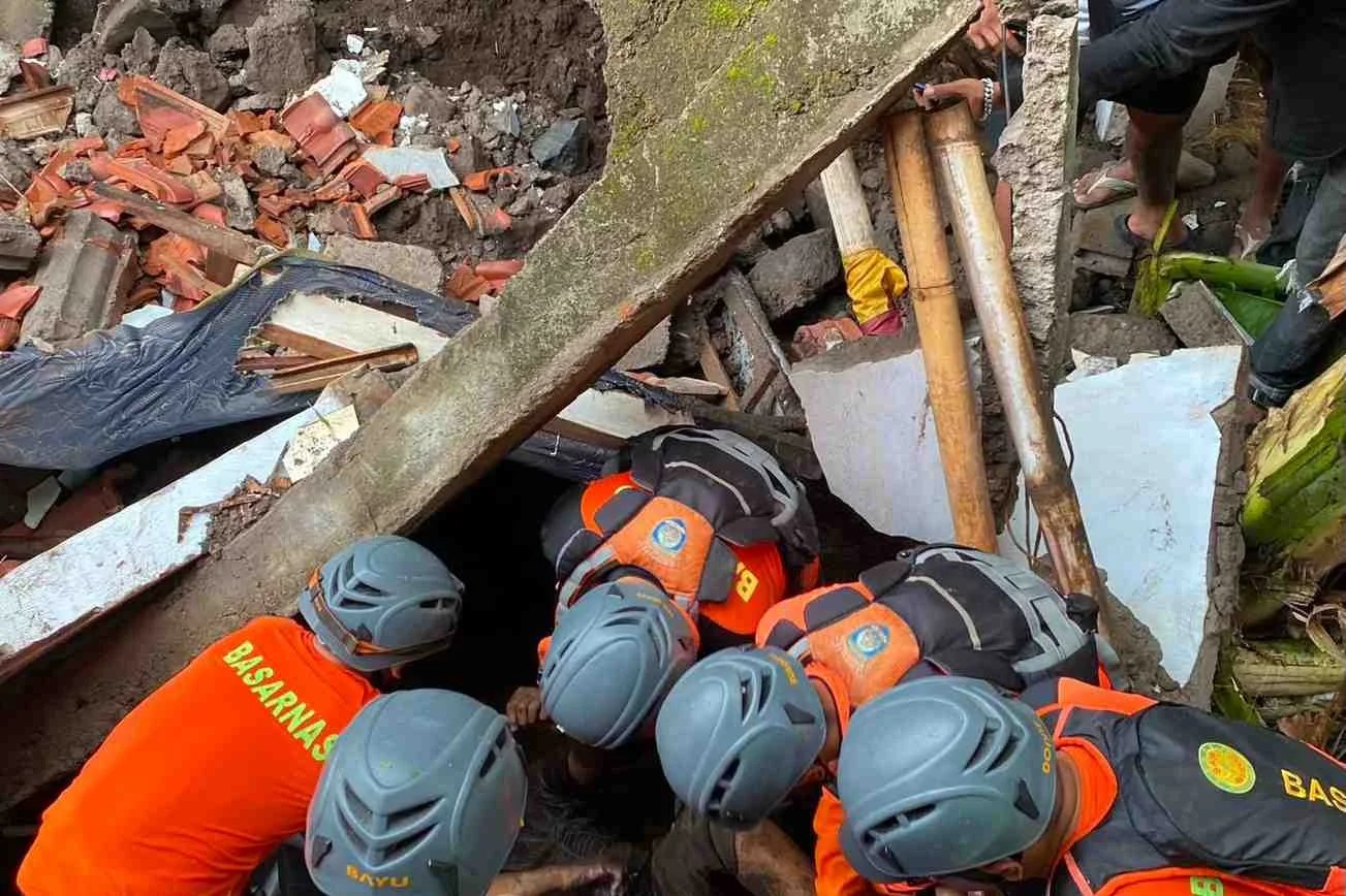 Tim SAR Gabungan saat mengevakuasi jenazah korban banjir berinisial RRA dari bawah reruntuhan rumah di Desa Bakti Seraga Buleleng.