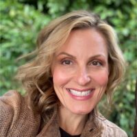 Smiling woman portrait outdoors amid green foliage