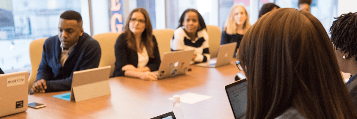 Business team meeting around table with laptops